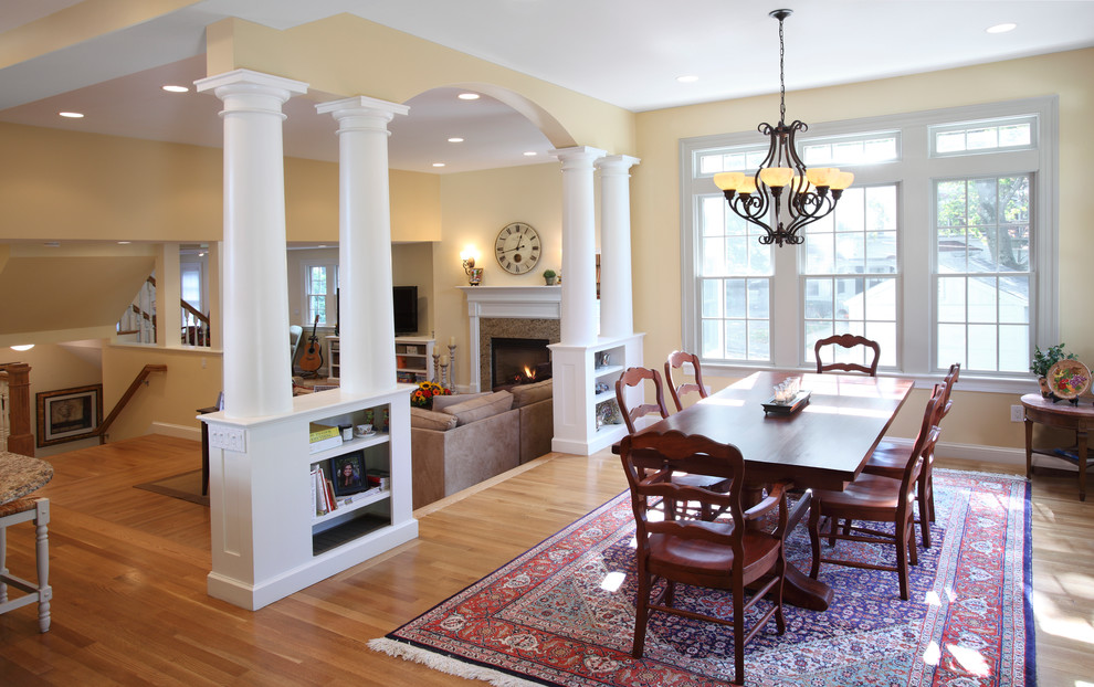 Cette photo montre une salle à manger ouverte sur le salon chic de taille moyenne avec un mur beige, parquet clair, une cheminée standard, un manteau de cheminée en carrelage et un sol marron.