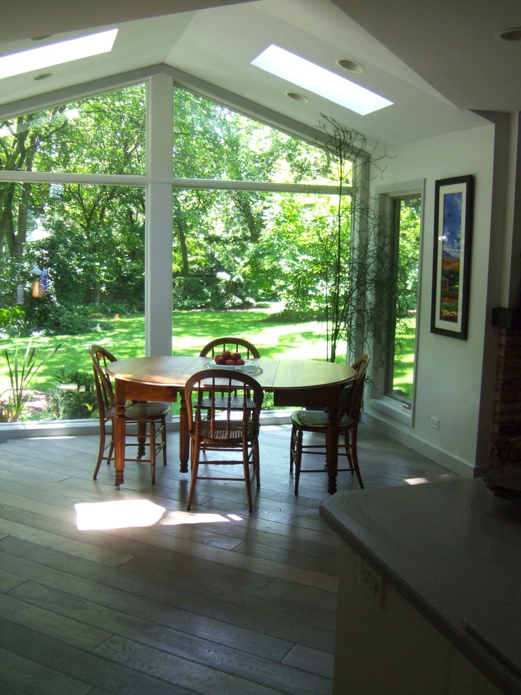 Immagine di una sala da pranzo aperta verso la cucina tradizionale di medie dimensioni con pareti bianche, parquet scuro e nessun camino