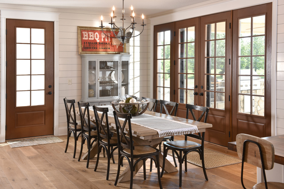 Idee per una sala da pranzo country con pareti bianche, pavimento in legno massello medio e pavimento marrone