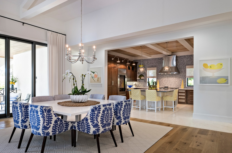 Immagine di una sala da pranzo aperta verso la cucina stile marinaro con pareti bianche, pavimento in legno massello medio e pavimento marrone
