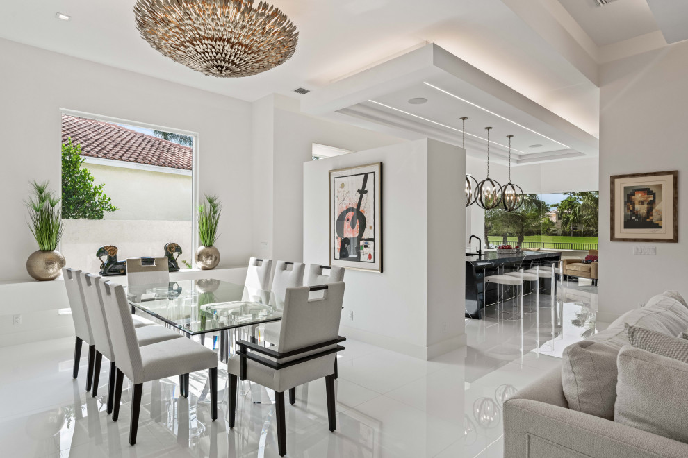 Inspiration pour une salle à manger ouverte sur le salon design avec un mur blanc et un sol blanc.