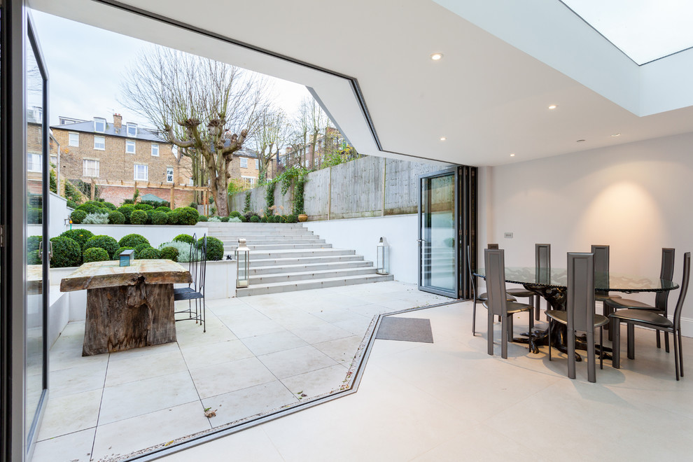 This is an example of an expansive classic kitchen/dining room in London with white walls and no fireplace.