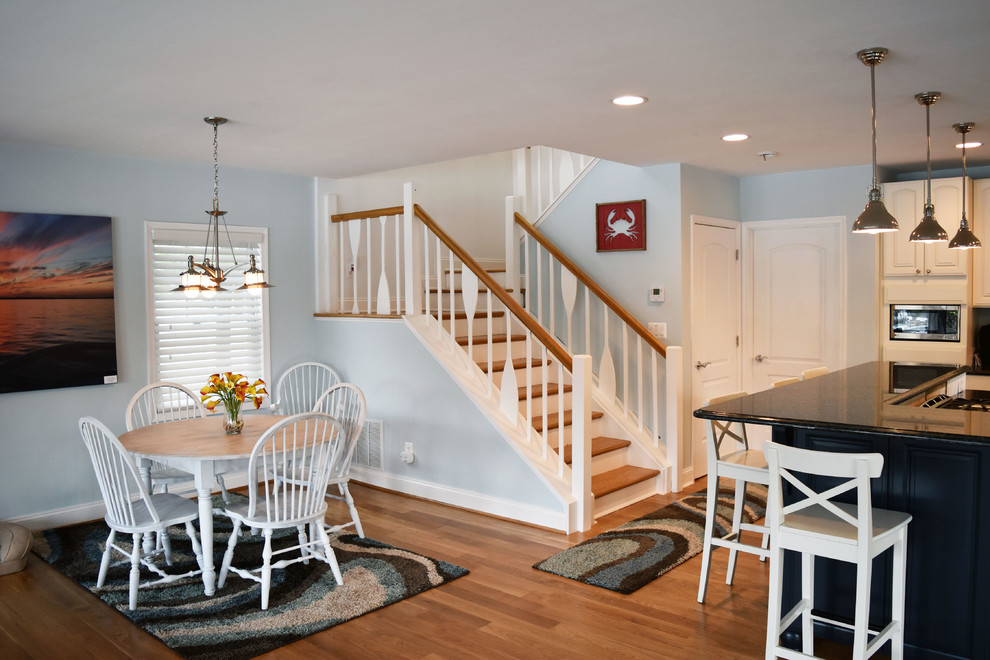 Esempio di una sala da pranzo aperta verso la cucina costiera di medie dimensioni con pareti blu, pavimento in legno massello medio, nessun camino e pavimento marrone
