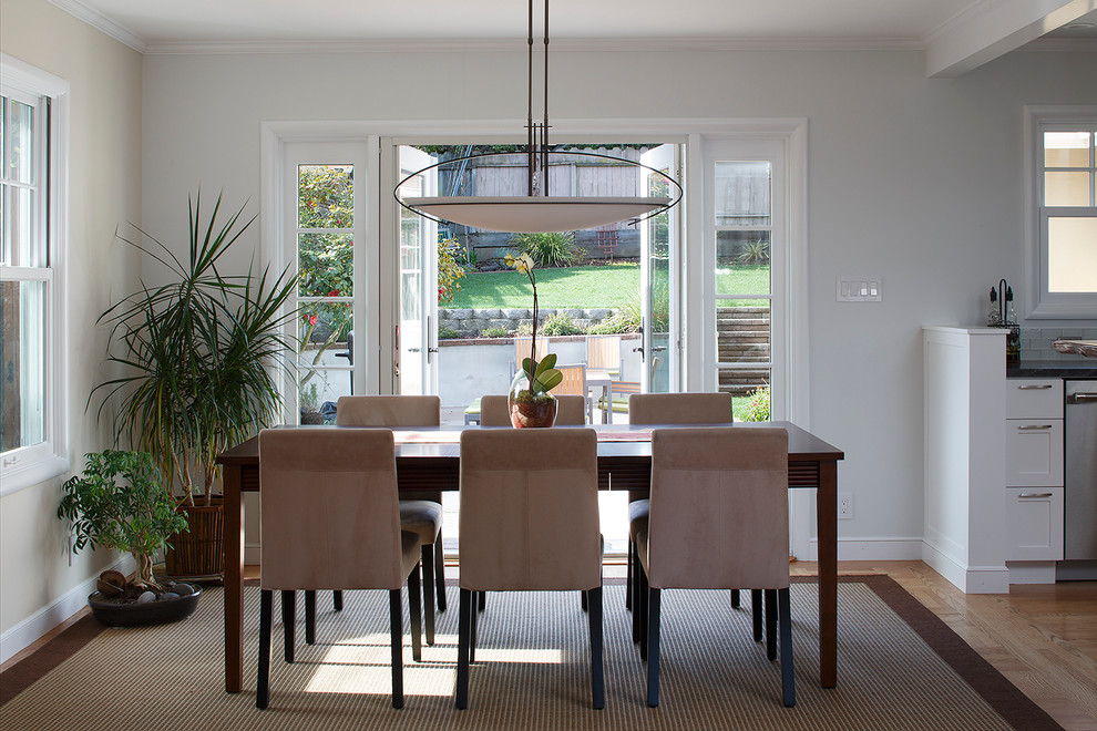 Ispirazione per una sala da pranzo aperta verso il soggiorno tradizionale con pareti bianche e pavimento in legno massello medio