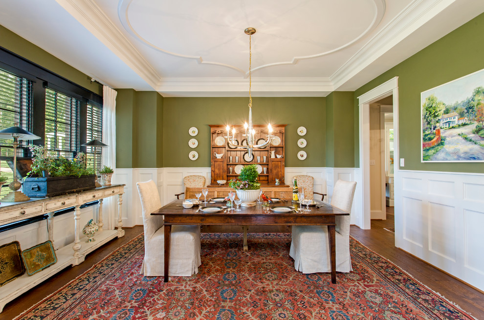 На фото: отдельная столовая в классическом стиле с зелеными стенами с