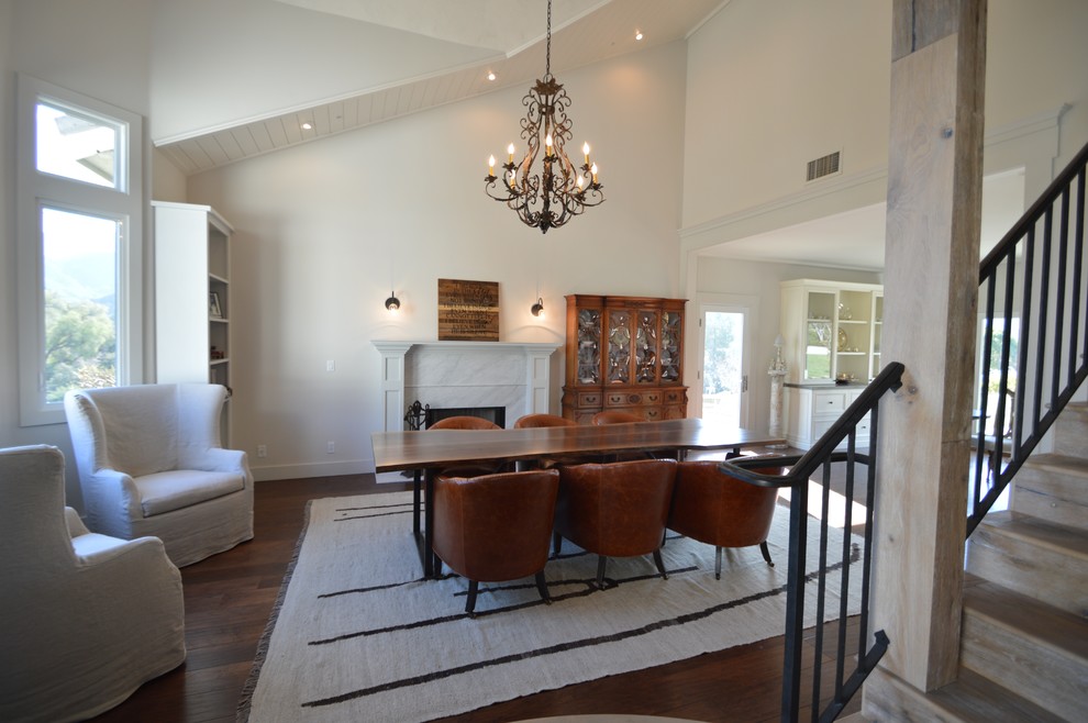 This is an example of a medium sized classic open plan dining room in Los Angeles with white walls, medium hardwood flooring, a standard fireplace and a stone fireplace surround.