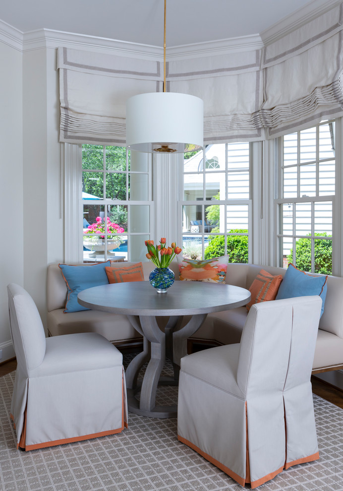 This is an example of a classic dining room in Charlotte with white walls, medium hardwood flooring and brown floors.