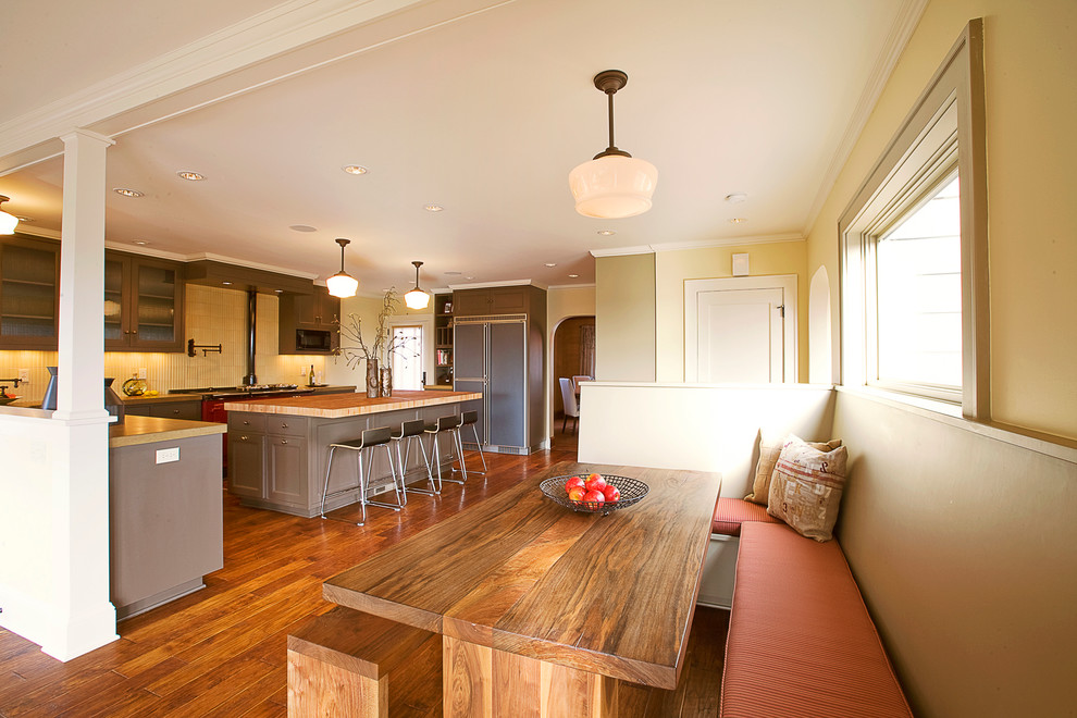 Klassische Wohnküche mit gelber Wandfarbe, braunem Holzboden und braunem Boden in Portland