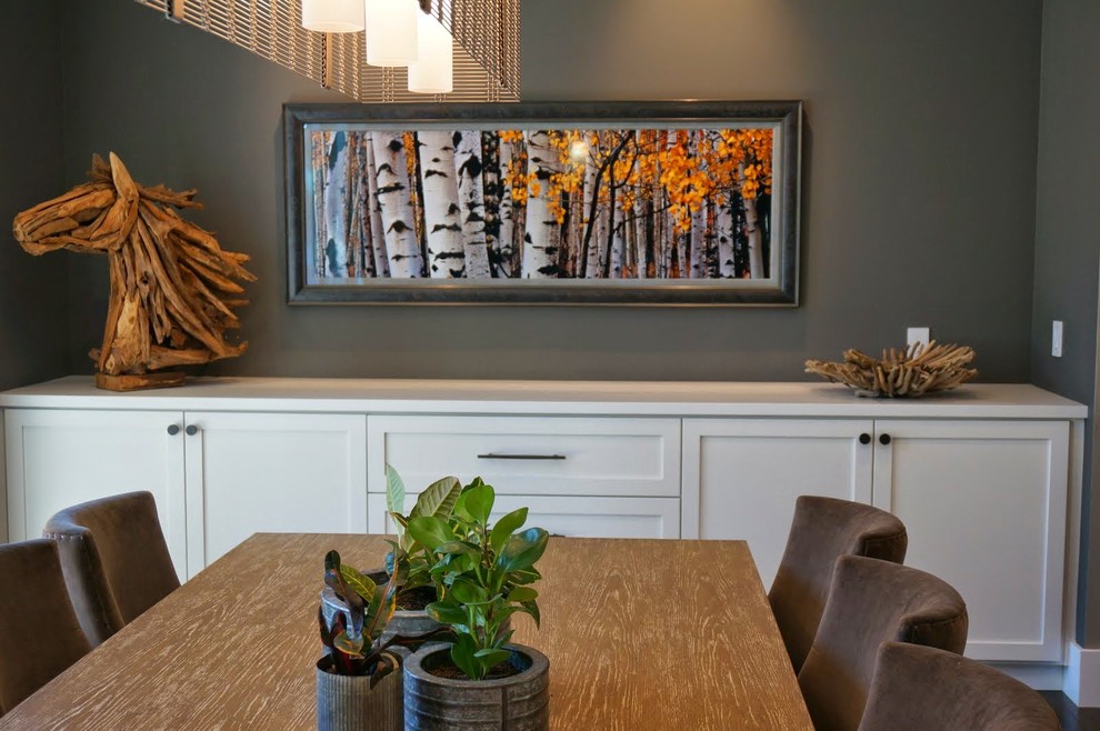 Exemple d'une grande salle à manger ouverte sur le salon nature avec un mur gris et un sol en bois brun.
