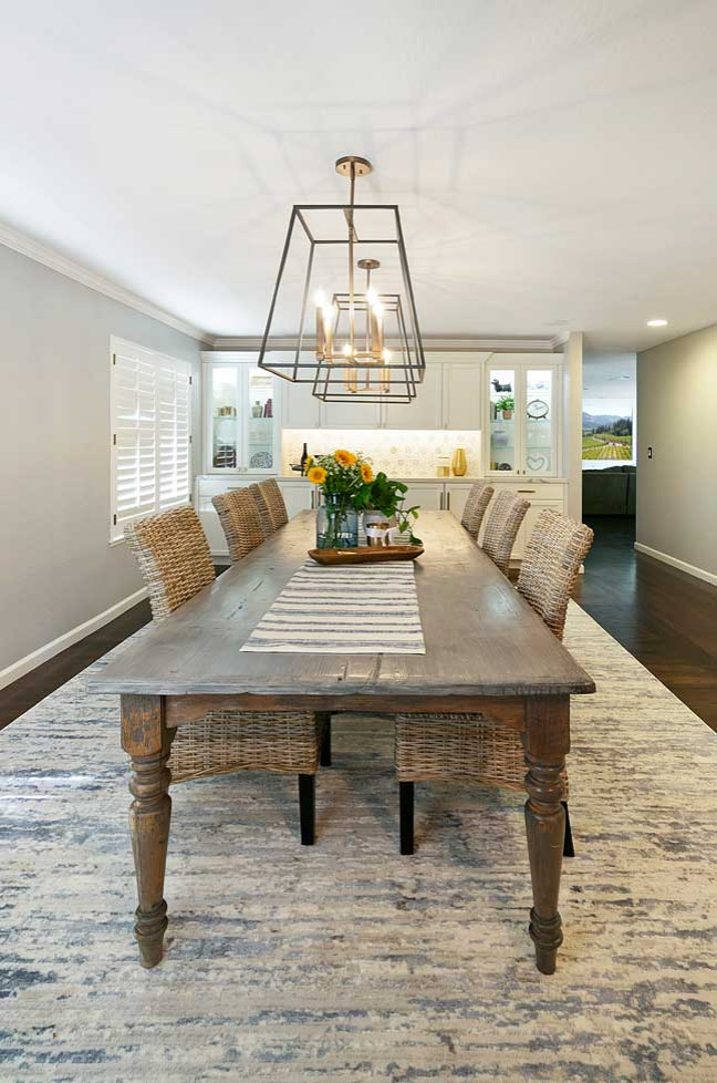 Idée de décoration pour une salle à manger ouverte sur le salon tradition de taille moyenne avec un mur gris, parquet foncé et un sol marron.