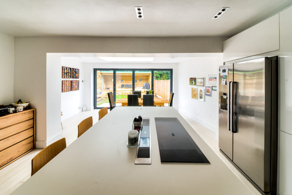 На фото: кухня-гостиная среднего размера в стиле модернизм с светлым паркетным полом и коричневым полом