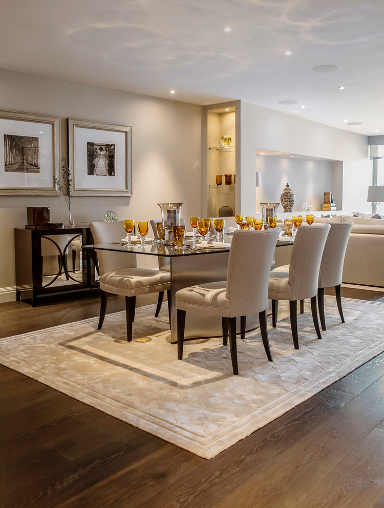 Classic open plan dining room in London with beige walls, dark hardwood flooring and feature lighting.