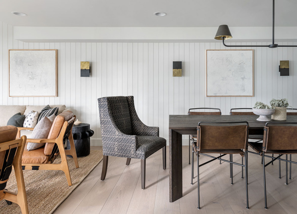 This is an example of a country dining room in Seattle with white walls, light hardwood flooring, beige floors and tongue and groove walls.