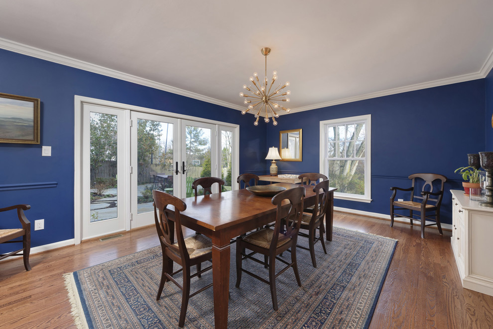 Example of a transitional medium tone wood floor dining room design in DC Metro with blue walls and no fireplace