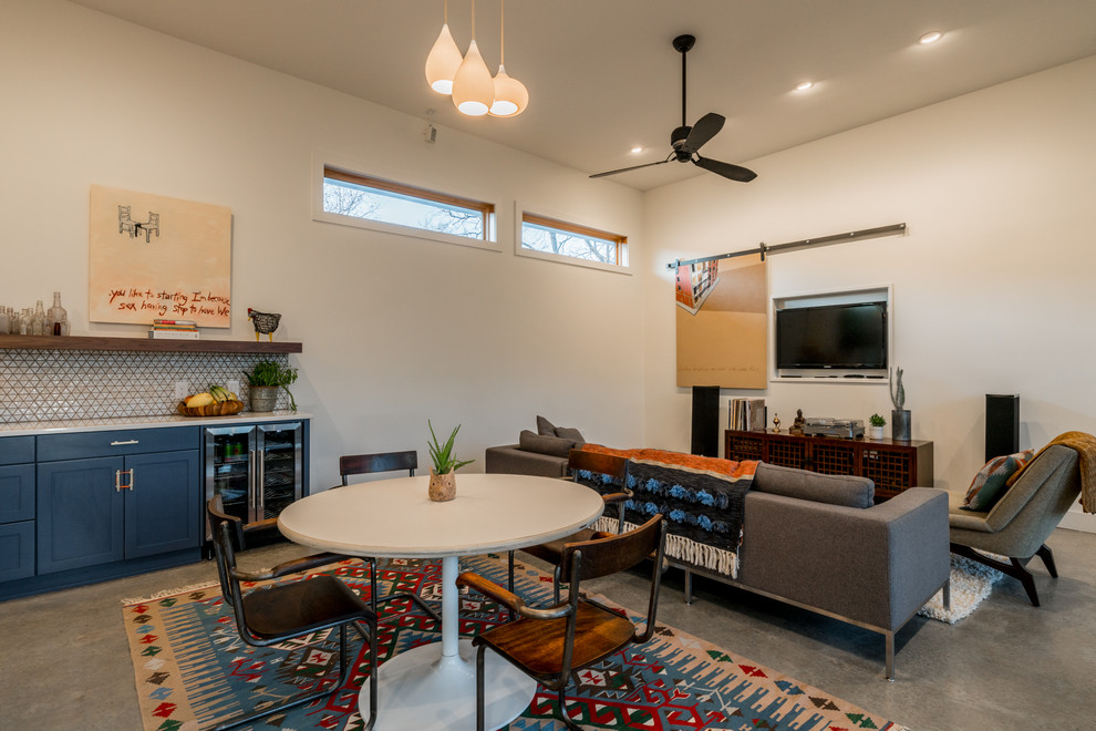 Immagine di una sala da pranzo aperta verso il soggiorno minimal con pareti bianche e pavimento in cemento