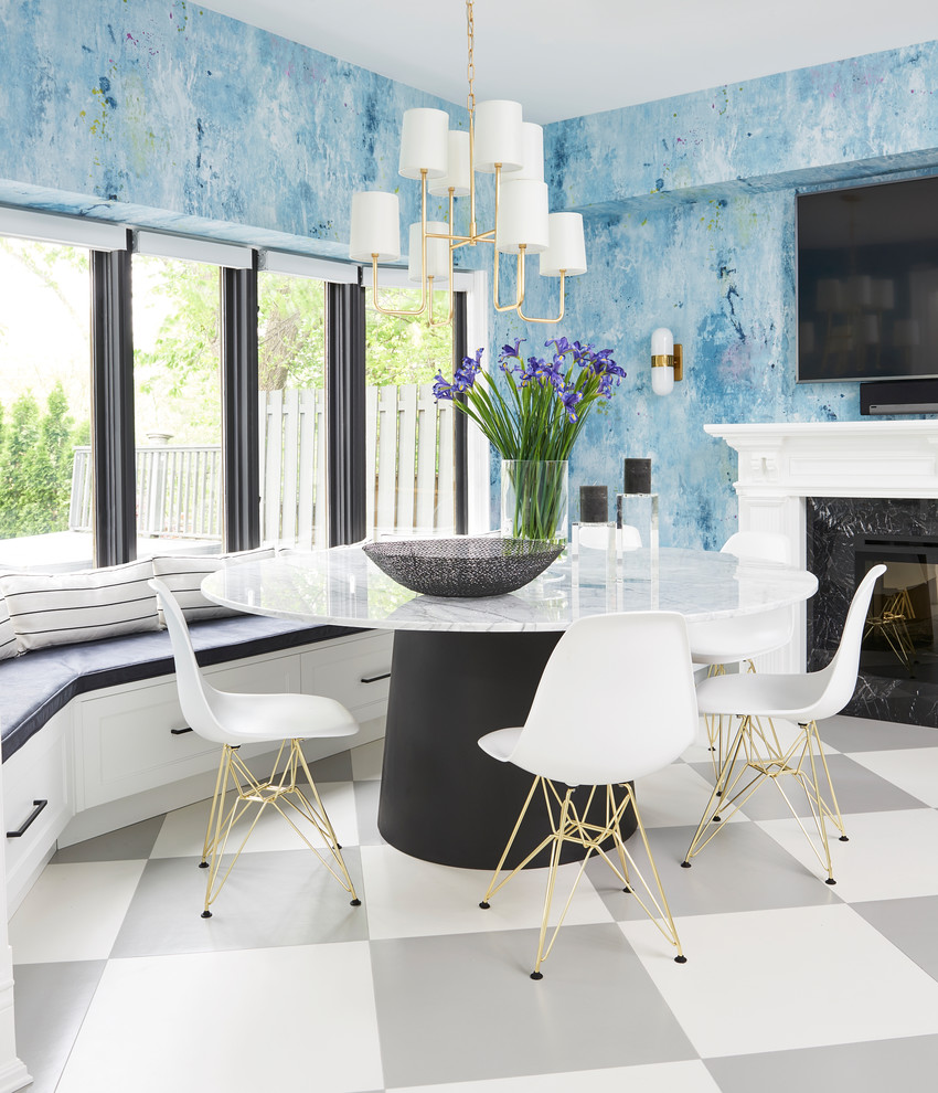 Inspiration pour une salle à manger traditionnelle avec un mur bleu, une cheminée standard, un manteau de cheminée en pierre et un sol multicolore.