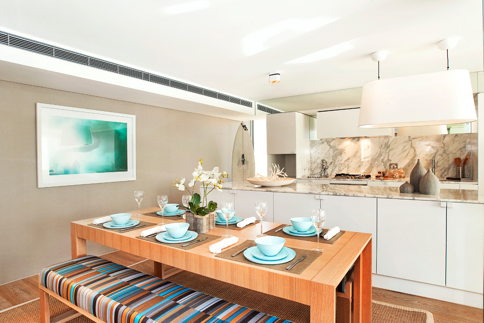 Immagine di una sala da pranzo aperta verso la cucina stile marino con pareti beige