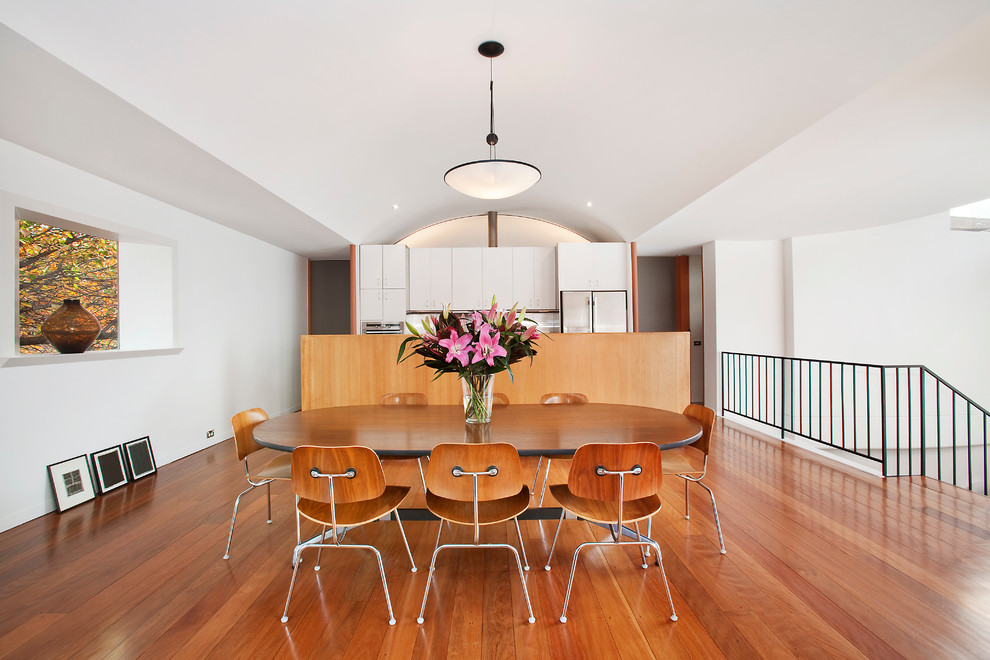 Esempio di una sala da pranzo aperta verso la cucina minimal con pareti bianche e pavimento in legno massello medio