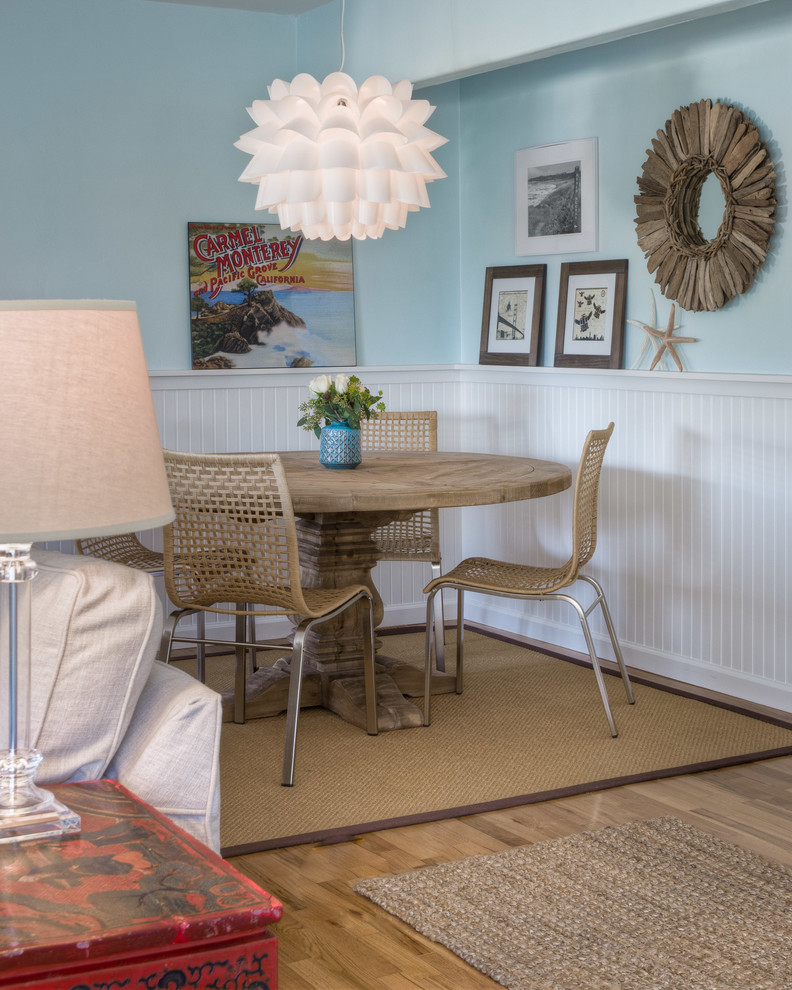 Imagen de comedor costero abierto con paredes azules y suelo de madera en tonos medios