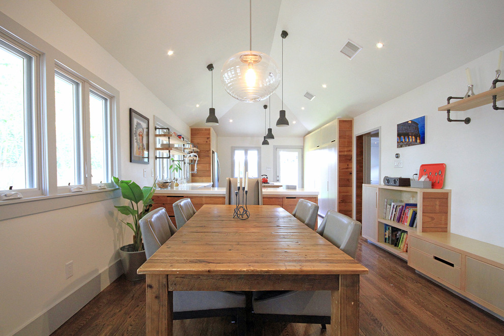 Esempio di una sala da pranzo aperta verso la cucina country di medie dimensioni con pareti bianche, pavimento in legno massello medio, nessun camino e pavimento marrone