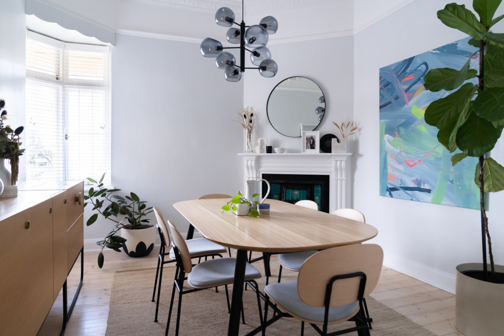 На фото: столовая в современном стиле с серыми стенами, светлым паркетным полом, угловым камином и бежевым полом с