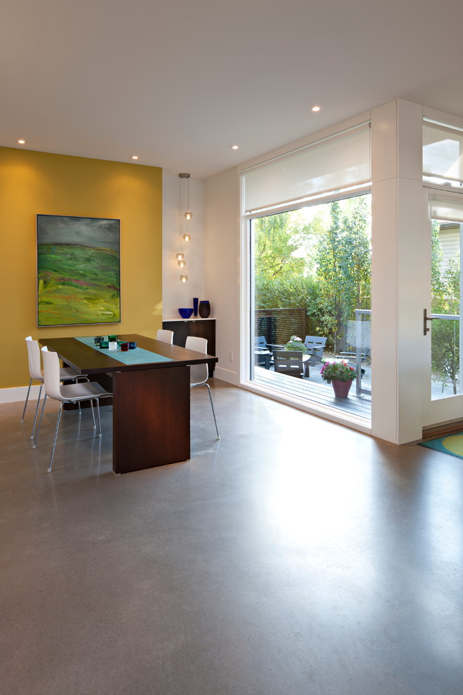 Offenes, Mittelgroßes Modernes Esszimmer ohne Kamin mit Betonboden, gelber Wandfarbe und grauem Boden in Calgary