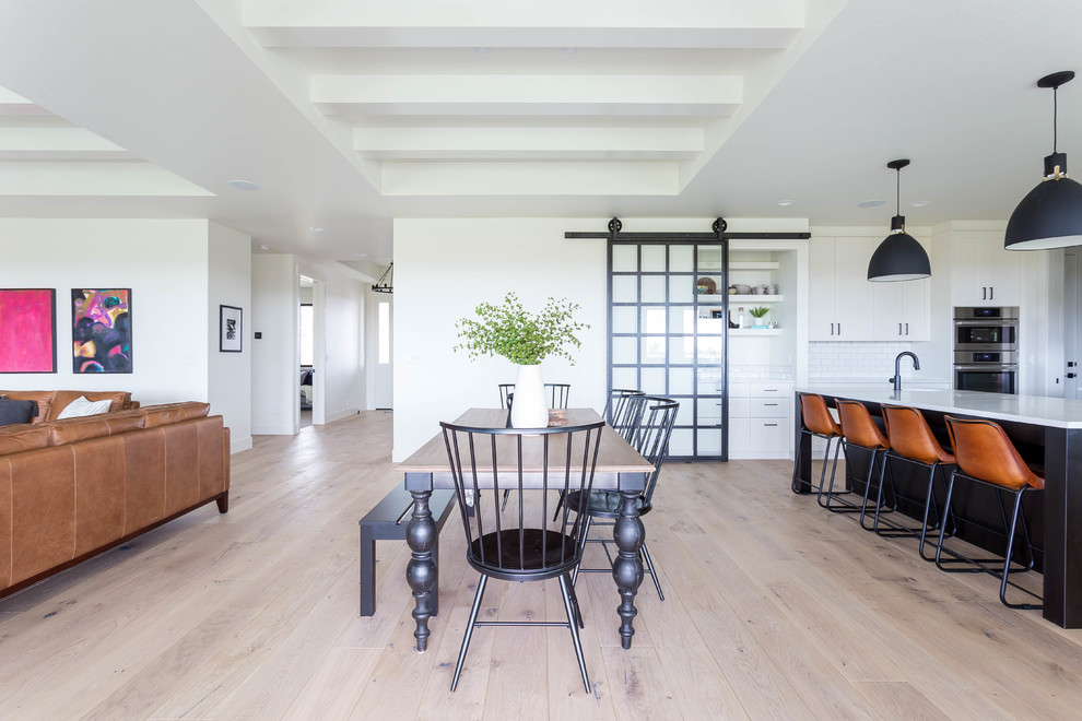 Esempio di una sala da pranzo aperta verso il soggiorno country con pareti bianche, parquet chiaro e pavimento beige