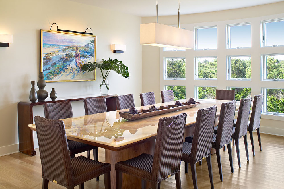 Idée de décoration pour une salle à manger marine avec un sol en bois brun et un mur jaune.