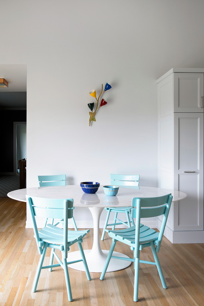 На фото: столовая в современном стиле с белыми стенами и светлым паркетным полом с