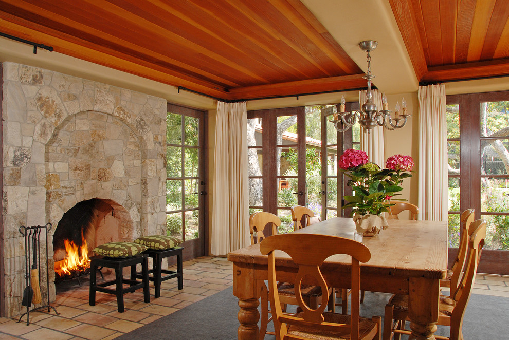 Design ideas for a mediterranean dining room in Los Angeles with a stone fireplace surround.