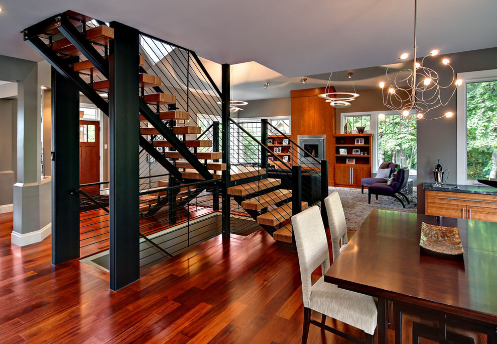 Idee per una grande sala da pranzo aperta verso il soggiorno minimal con pareti grigie e pavimento in legno massello medio