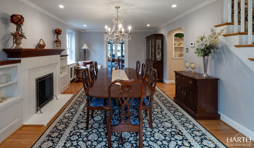 This is an example of a medium sized traditional enclosed dining room in Philadelphia with blue walls, medium hardwood flooring, a standard fireplace, a stone fireplace surround and brown floors.