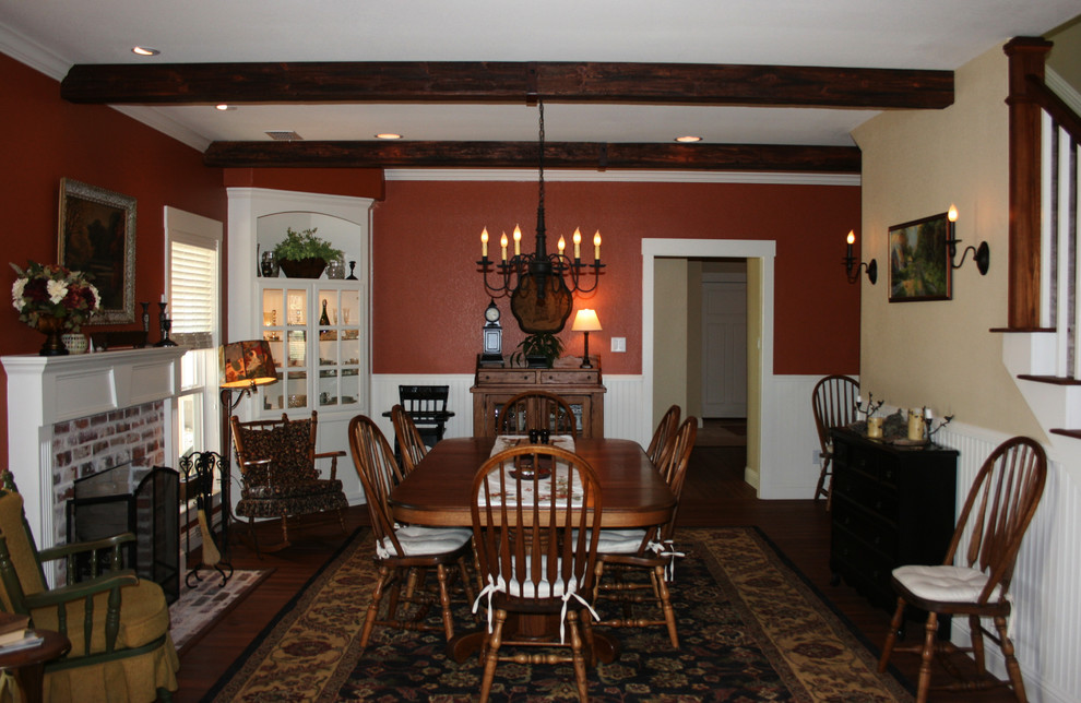 Foto di una sala da pranzo aperta verso la cucina country di medie dimensioni con pareti rosse, pavimento in legno massello medio e camino classico