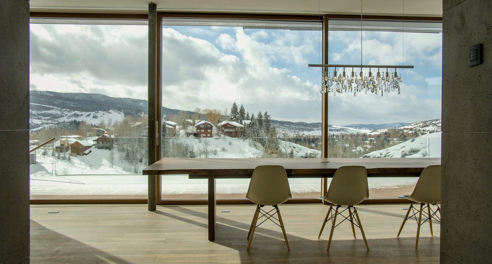 Foto di una grande sala da pranzo aperta verso la cucina minimalista con pareti bianche, parquet chiaro e pavimento beige