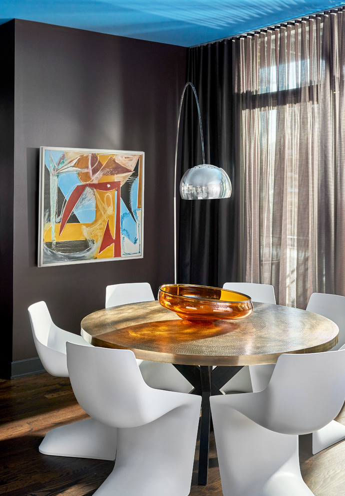 Photo of a medium sized contemporary open plan dining room in Chicago with dark hardwood flooring, no fireplace, black walls and feature lighting.