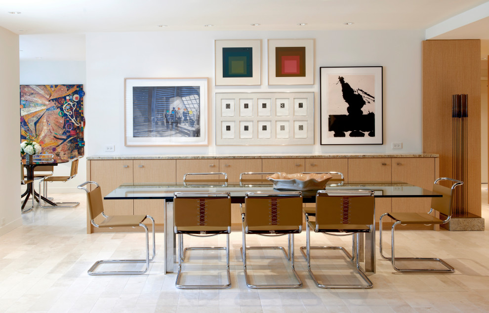 Cette image montre une grande salle à manger design avec une banquette d'angle, un mur blanc, un sol en calcaire, un sol beige et du lambris.