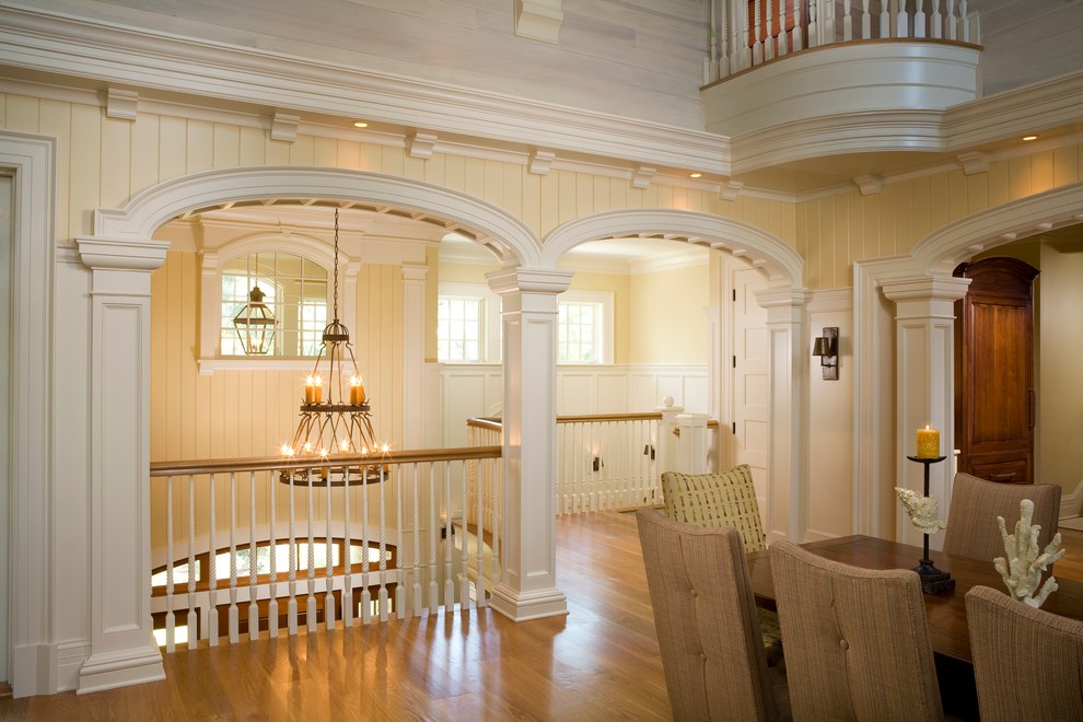 Idee per una grande sala da pranzo aperta verso il soggiorno tradizionale con pareti gialle, pavimento in legno massello medio e nessun camino