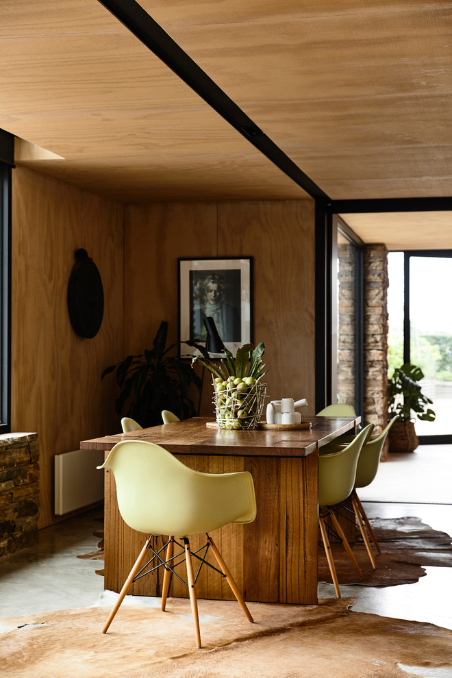 Modernes Esszimmer mit beiger Wandfarbe, Betonboden und grauem Boden in Melbourne