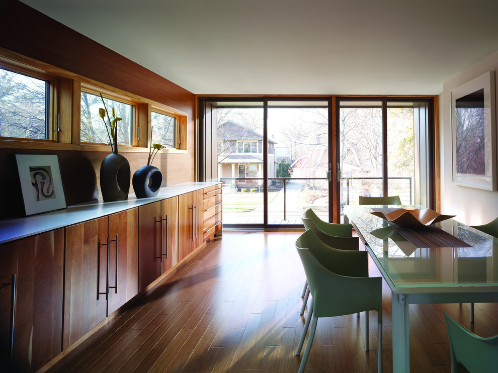 Immagine di una grande sala da pranzo aperta verso la cucina minimal con pareti bianche, pavimento in legno massello medio e pavimento marrone