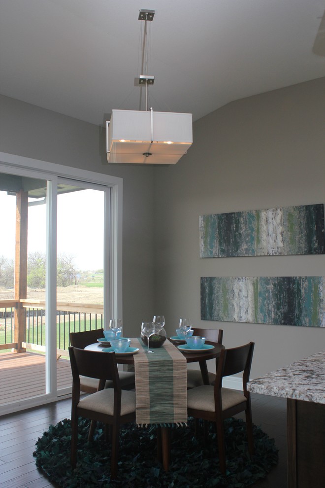 Exemple d'une salle à manger ouverte sur la cuisine chic de taille moyenne avec un mur gris et parquet foncé.
