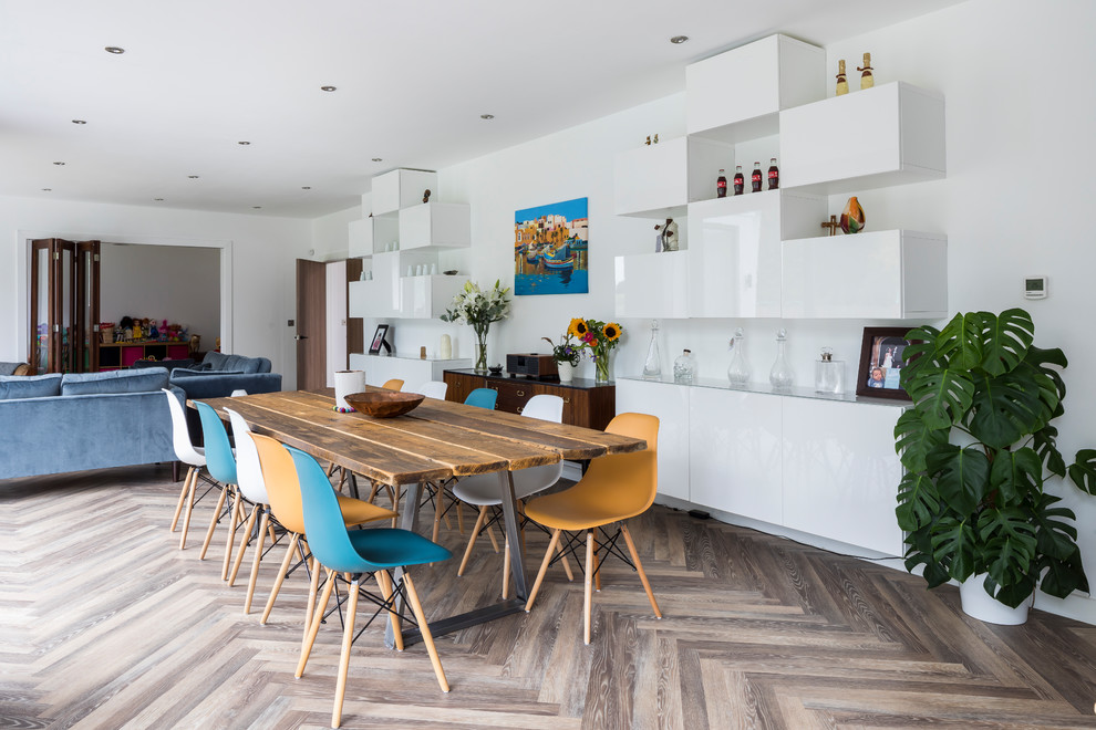 Design ideas for a medium sized contemporary dining room in London with white walls, light hardwood flooring, grey floors and feature lighting.