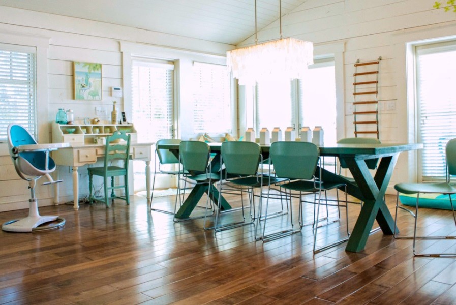 Idee per una sala da pranzo aperta verso il soggiorno costiera con pareti bianche, pavimento in legno massello medio e nessun camino