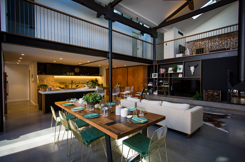 Foto di una sala da pranzo aperta verso la cucina minimal di medie dimensioni con pareti bianche e pavimento in cemento
