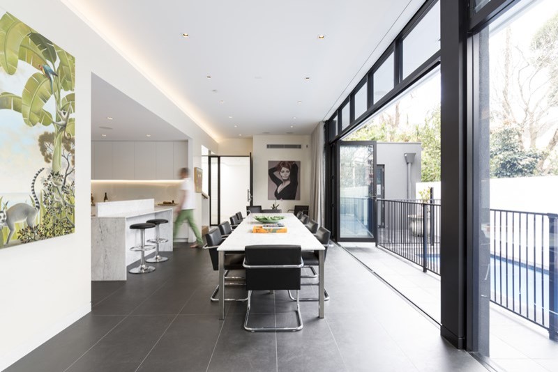 Foto di una sala da pranzo aperta verso il soggiorno moderna di medie dimensioni con pareti bianche, pavimento con piastrelle in ceramica e pavimento nero