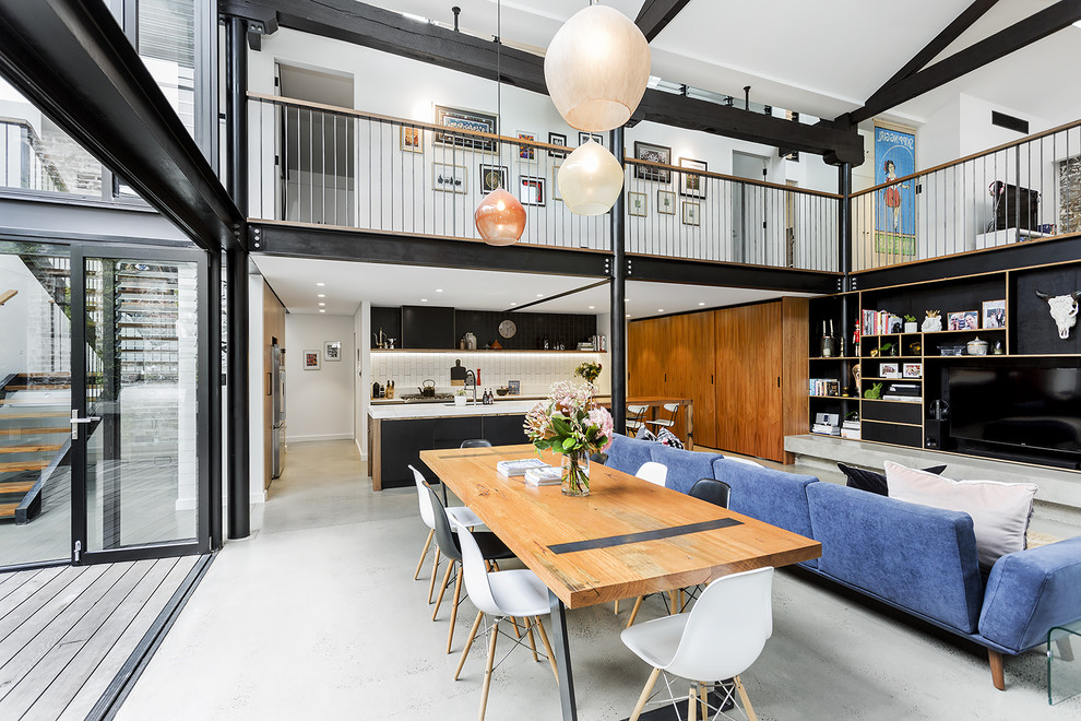 Expansive urban open plan dining room in Sydney with concrete flooring.