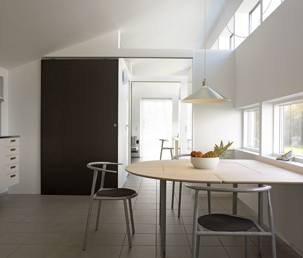 На фото: кухня-столовая среднего размера в стиле лофт с разноцветными стенами и серым полом с