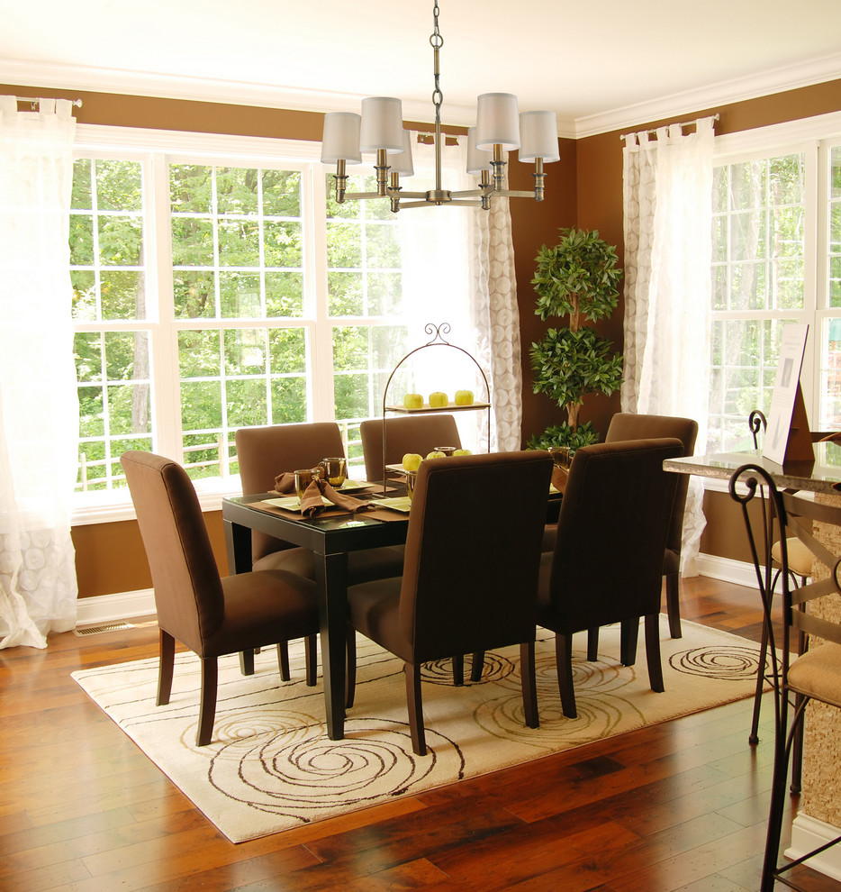 Exemple d'une salle à manger ouverte sur la cuisine tendance de taille moyenne avec un mur marron, un sol en bois brun et aucune cheminée.