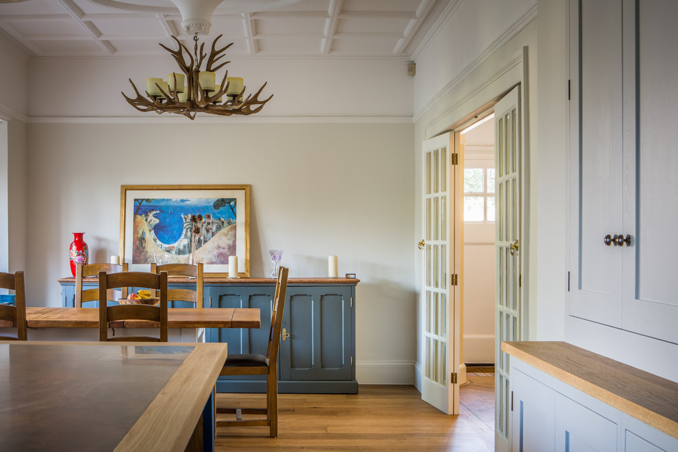 Foto di una grande sala da pranzo aperta verso la cucina tradizionale con parquet chiaro