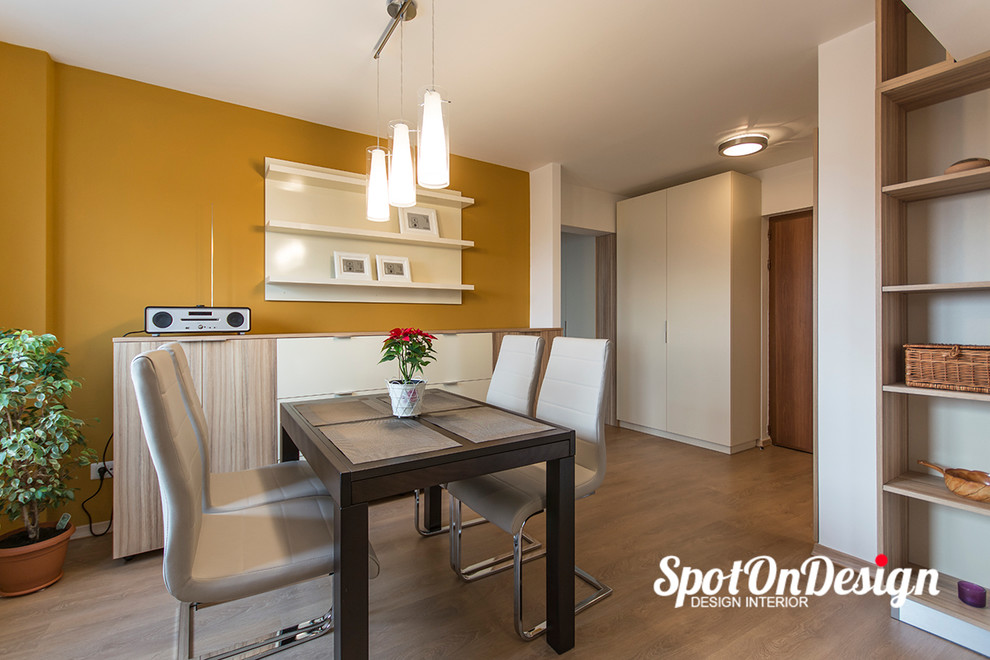 Esempio di una piccola sala da pranzo aperta verso la cucina minimalista con pareti multicolore e parquet chiaro