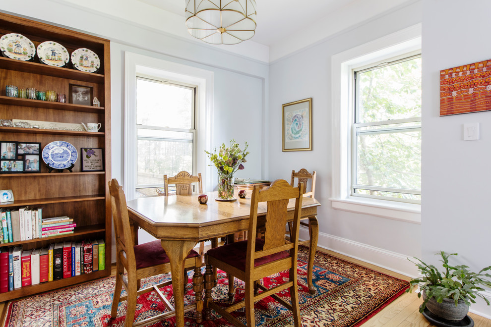 This is an example of a traditional dining room in New York with grey walls, light hardwood flooring and beige floors.
